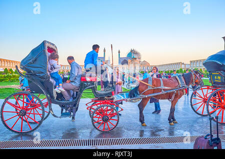 ISFAHAN, IRAN - 19. Oktober 2017: Die Familie mit einem Kind für eine fröhliche Fahrt aroun Nashq-e Jahad Square in das pferd kutsche vorbereiten, auf Octobe Stockfoto