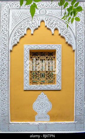 Die typischen, alten, reich verzierten, kunstvoll geschnitzten, Nieten, marokkanische Riad Fenster und Rahmen und altes Haus. Schöne Aussicht auf die blaue Wand in der Medina. Stockfoto