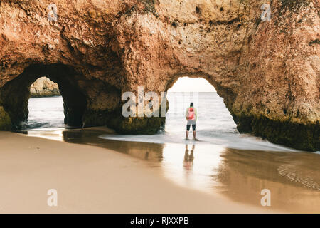 Mann erkunden Klippen und Felsformationen von Water's Edge, Alvor, Algarve, Portugal, Europa Stockfoto