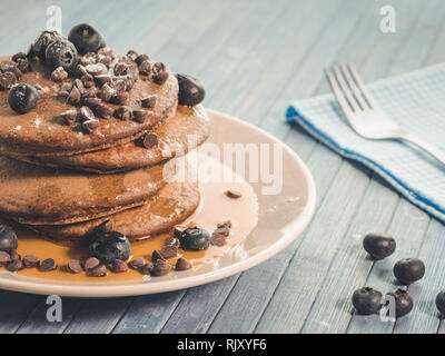 Kakao Pfannkuchen mit Schokolade Tropfen und Heidelbeeren, original amerikanisches Frühstück mit Ahornsirup Stockfoto