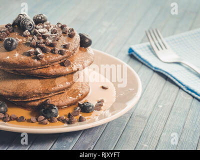 Kakao Pfannkuchen mit Schokolade Tropfen und Heidelbeeren, original amerikanisches Frühstück mit Ahornsirup Stockfoto