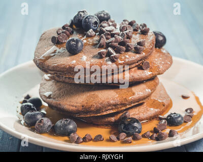 Kakao Pfannkuchen mit Schokolade Tropfen und Heidelbeeren, original amerikanisches Frühstück mit Ahornsirup Stockfoto