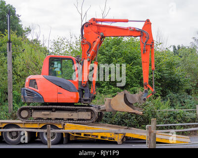 Kleine Raupenbagger auf einem Tieflader Transporter geladen. Stockfoto