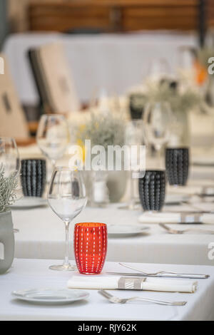 Wein, Gläser, Teller und Besteck auf dem Tisch vor dem Start des Service im Restaurant Stockfoto