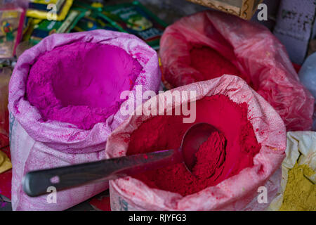 Taschen von farbigen Pulver Farbe sitzen warten auf Holi Festival Zelebranten in Barsana, Indien verkauft werden Stockfoto