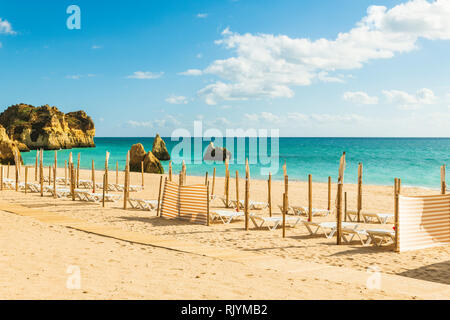 Reihe der Leere Liegestühle, Windschutz am Sandstrand, Alvor, Algarve, Portugal, Europa Stockfoto