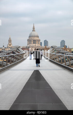 Die Menschen sind zu Fuß in Richtung St. Paul's Cathedral über die Millenium Fußgängerbrücke. Die Brücke überspannt den Fluss Themse in London, England in der Nähe von Tate Modern. Stockfoto