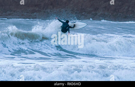 Swansea, Großbritannien. 08 Feb, 2019. UK Wetter: Surfer an Langland Bay in der Nähe von Swansea heute Nachmittag als Sturm Erik fährt fort, die Großbritannien zu zerschlagen. Credit: Phil Rees/Alamy leben Nachrichten Stockfoto