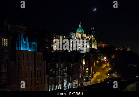 Edinburgh, Schottland, Großbritannien, 8. Februar 2019. UK Wetter: Royal Bank of Scotland gewölbte Hauptquartier, die Market Street und Edinburgh Castle mit einem waxing Crescent Moon mit Gebäuden in der Nacht beleuchtet Stockfoto