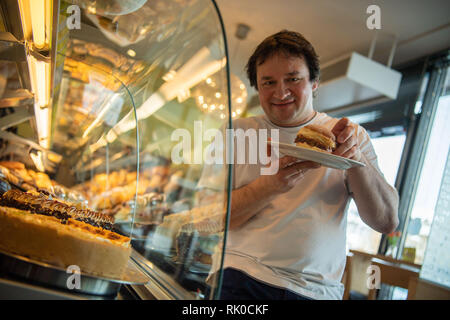 Miesbach, Deutschland. 07 Feb, 2019. Bäckermeister Florian Perkmann hält einen Donut mit Meat Loaf und süßen Senf gekrönt. Nach dem Leberkäs-Krapfen aus Oberbayern, die Goaßmaß-Krapfen kommt jetzt aus Niederbayern. Eine Goass Maßnahme ist ein gemischtes Getränk Bier, Cola und kirschlikör. (Dpa vom 09.02.2019) Credit: Lino Mirgeler/dpa/Alamy leben Nachrichten Stockfoto