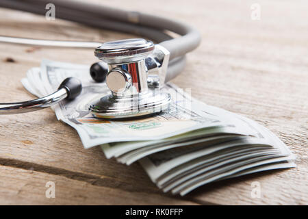 Krankenversicherung Konzept - Stethoskop über das Geld auf dem Tisch Stockfoto