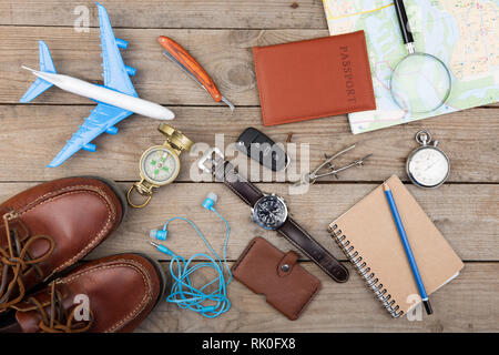 Glas mit Geld für eine Reise, Flugzeug, Karten, Reisepass, und andere Sachen für Abenteuer auf dem Tisch Stockfoto