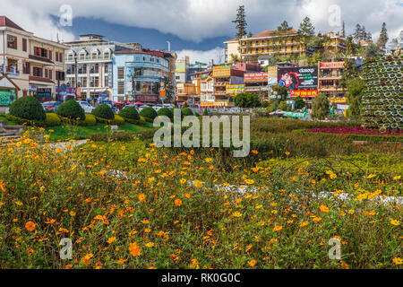 Sapa, Vietnam - November 20, 2018: Blick auf die Straße der Stadt Sapa vom Park in der Nähe des Sees. Blumenbeet im Vordergrund. Stockfoto