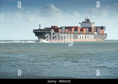 NYK Line Containerschiff, NYK NEBULA, nähert sich der Hafen von Southampton, Southampton Hafen Master Pilot Boot im Vordergrund. Vereinigtes Königreich. Stockfoto