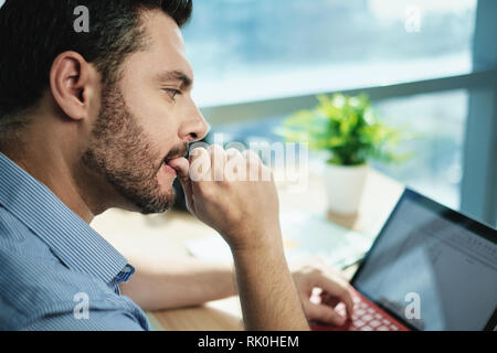 In dem Bestreben, Geschäftsmann Beißen Nägel Arbeiten mit Laptop im Büro Stockfoto