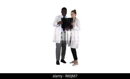 Ernsthafte nette Frau Doktor und afro-amerikanische Arzt Studie Gehirn x-ray auf weißem Hintergrund. Stockfoto