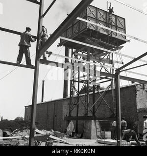 1950, historische, Arbeiten an einem Gebäude oder einer Baustelle für eine neue Fabrik ... nicht einen harten Hut in Sicht! Stockfoto