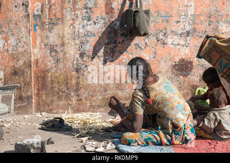 Obdachlose Rajasthani Mutter wacht auf, mit ihren Kindern an einem kühlen Morgen in Jaipur. Armut ist ein großes Problem in Indien. Stockfoto