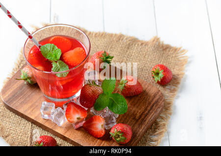 Erdbeersaft und Pfefferminze oben und frische Erdbeeren auf Holz Block, Sommer Getränke Konzept Stockfoto