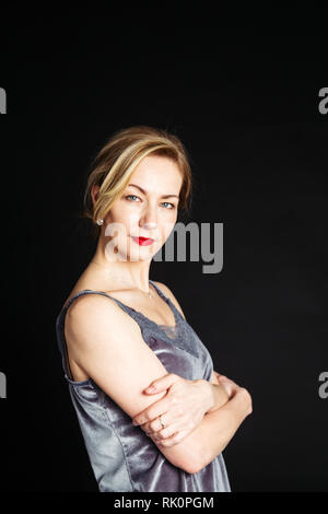 In der Nähe von Studio Porträt der schönen Frau in einem Kleid aus Seide auf schwarzem Hintergrund Stockfoto
