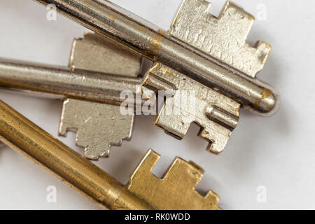 Close-up Detail des Alten metallischen Schlüssel Edelstahl und Gelb auf weißem Hintergrund. Sicherheits- und Sicherheitskonzept. Stockfoto