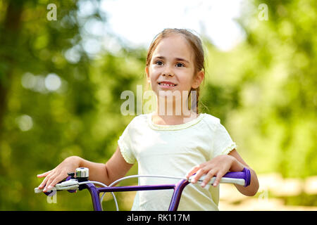 Glückliche kleine Mädchen mit dem Fahrrad im Sommer Stockfoto