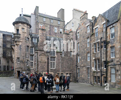 Touristen auf Tour zu Fuß im Makars' Court mit dem Writers Museum nach hinten in der Altstadt von Edinburgh, Schottland, Großbritannien Stockfoto