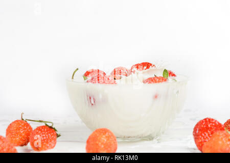 Frische Milch mit hausgemachten süßen Erdbeeren auf einem weißen Hintergrund. Stockfoto