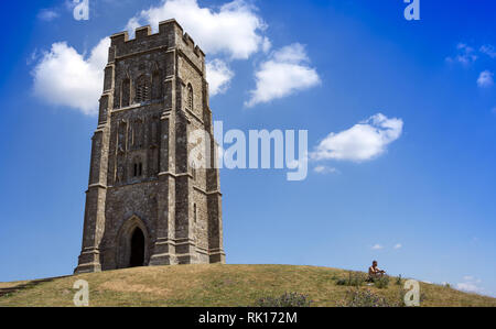 Mann in der Sonne auf der Oberseite des Glastonbury Tor neben der St. Michael's Tower, Somset, England, Großbritannien Stockfoto