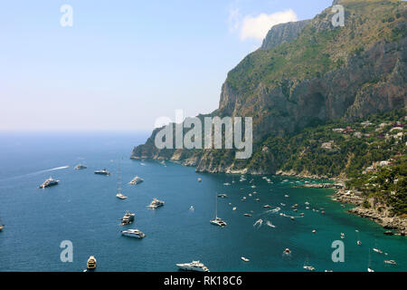 Spektakuläre Aussicht auf Capri felsige Küste mit England Yatchs und Luxus Schiffe in blau türkis Meer, die Insel Capri, Kampanien, Italien Stockfoto