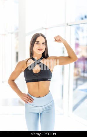 Schöne starke muskulöse Frau ihren Bizeps und arm Muskeln. Weibliche Körper Builder Stockfoto