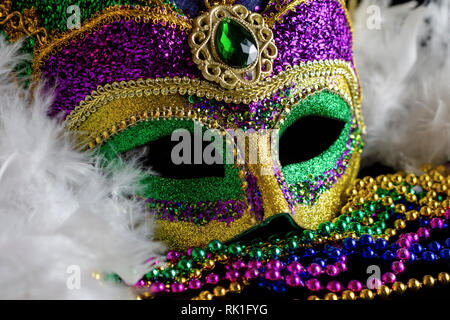 Nahaufnahme eines jester Maske mit einem weißen Boa und Farbe Perlen zu koordinieren. Konzeptionelle für Mardi Gras, Karneval, oder Festivals. Stockfoto