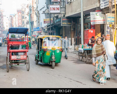 Traditionelle Rikscha und Tuktuk auf einer Straße in Neu Dehli. Die grünen und gelben tuktuks sind ikonisch für Dehli. Stockfoto