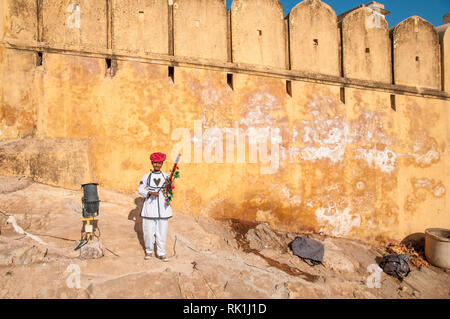 Rajasthani Mann mit traditionellen Instrument außerhalb Amer fort, die 1592 abgeschlossen wurde die Residenz der Rajput Maharajas in Jaipaur, Indien. Stockfoto