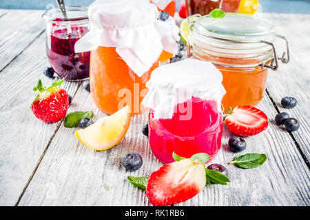 Sortiment von verschiedenen saisonalen Beeren und Obst Konfitüre in Gläser auf Holztisch. Platz kopieren Stockfoto