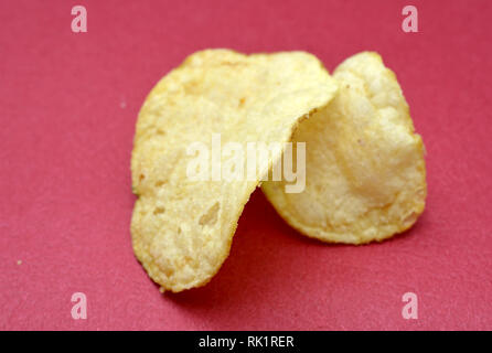 Kartoffelchips auf rotem Hintergrund, Bild Stockfoto
