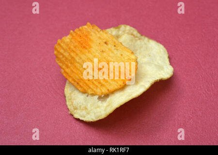 Kartoffelchips auf rotem Hintergrund, Bild Stockfoto