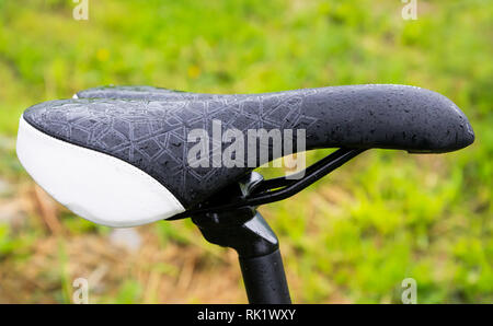 Nahaufnahme eines nassen Fahrrad nach Regen von Mountain Bike. Auf grünem Gras Hintergrund. Stockfoto