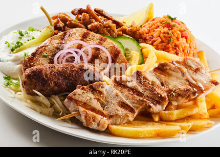 Verschiedene Fleisch vom Grill mit gebratenen Pommes, Reis und Salat auf einem Schild in der Nähe zu sehen, der regionalen Gerichte der griechischen Küche serviert. Stockfoto