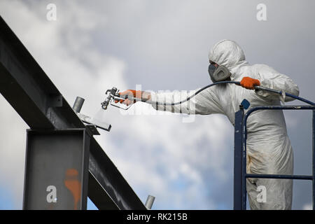 Handwerker sprühen Farben die Stahlträger auf der Baustelle Stockfoto