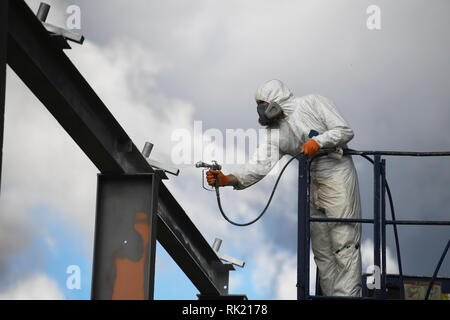 Handwerker sprühen Farben die Stahlträger auf der Baustelle Stockfoto