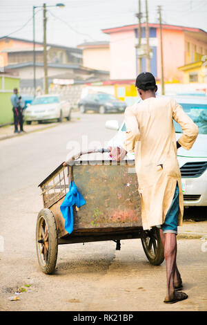 Städtische Aufträge - eine Art Schnitzeljagd in den Straßen von Lagos mit seinen Warenkorb Stockfoto