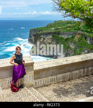 Weiblichen kaukasischen Touristen für ein Foto bei Uluwatu Tempel compound Posing, Bali, Indonesien. Stockfoto