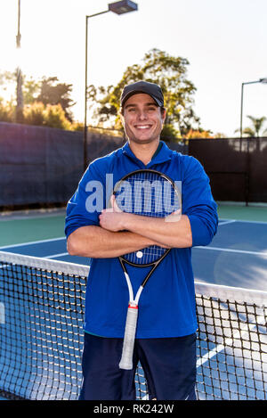 Ansicht schließen von jung und gut aussehend Tennis Unterricht professionelle zeigen, lächeln und glücklich Ausdruck auf dem Tennisplatz. Stockfoto