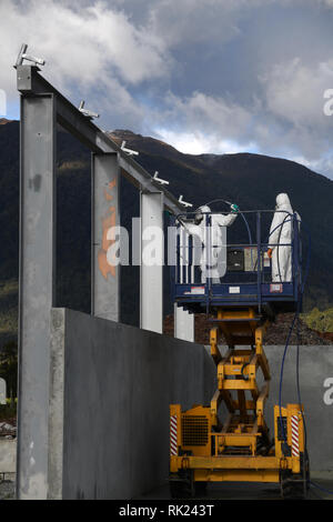 Handwerker mit einem Scherenhub die Stahlträger auf einer Baustelle zu spraypaint Stockfoto