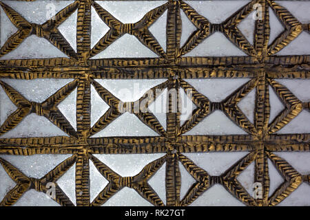 Alte geschnitzte hölzerne Gitter mit Blumen und Quadrate design Erstellen einer gelochten Mauer. Stockfoto