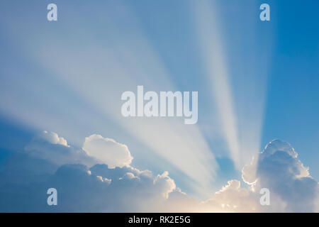 Schöne ruhige am frühen Morgen Himmel mit Weiche charmante weiße gerade echte Sonnenstrahlen aus über flauschigen weissen Wolken am blauen Himmel Hintergrund isoliert. Stockfoto