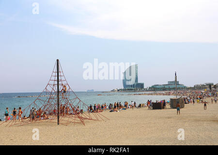 BARCELONA, SPANIEN - 11. JULI 2018: herrliche Aussicht auf den Strand von Barceloneta mit Personen, sonnigen Tag in Barcelona und W Hotel auf Hintergrund, Katalonien, Stockfoto