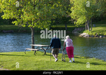 SYCAMORE, Illinois - 23. Mai 2014: Ein älteres Ehepaar zu Fuß zu einem Picknick Bank von einem Teich am Nachmittag an den Platanen RV Park in der Platane, IL Mai Stockfoto