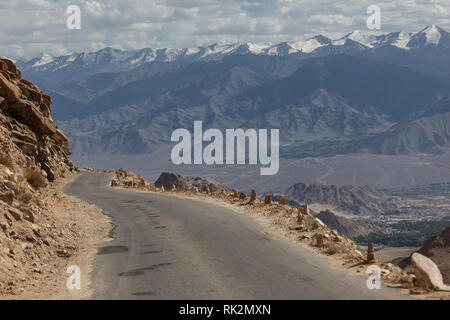 Mountainbiken Die eine einspurige Schotterstraße Wicklung über die kargen Berge der Khardungla Durchlauf in Tibet Stockfoto